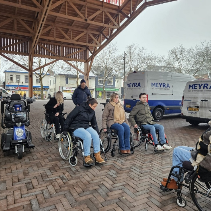 Mensen in een rolstoel op een plein